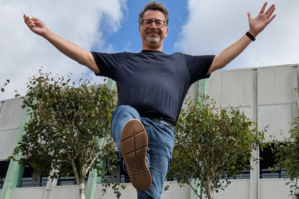 Photo of Rod balancing on a bench with blue sky