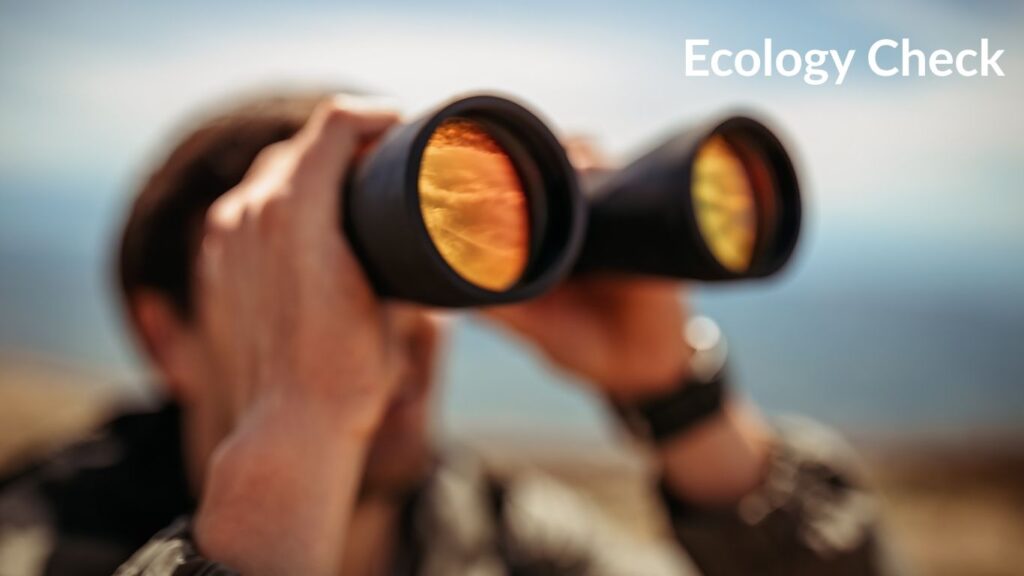 person focusing and refocusing looking through binoculars